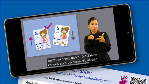 Handyblildschirm mit dem DGS-Video der Spielanleitung. Darunter die gedruckte Version der Spielanleitung.