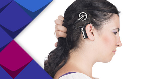 Eine Frau hält ihre Haare beiseite, so dass man ihr Cochlea Implantat sehen kann.