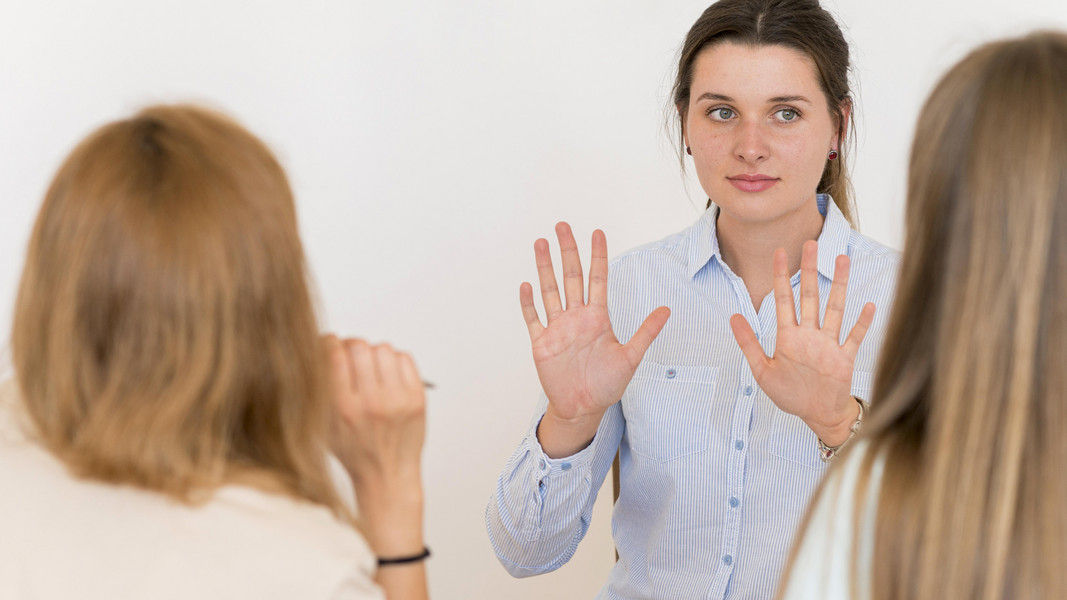 Die Frau zeigt "Stop" in Gebärdensprache